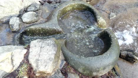 River-flowing-through-primitive-weathered-eroded-smooth-worn-stone-basin