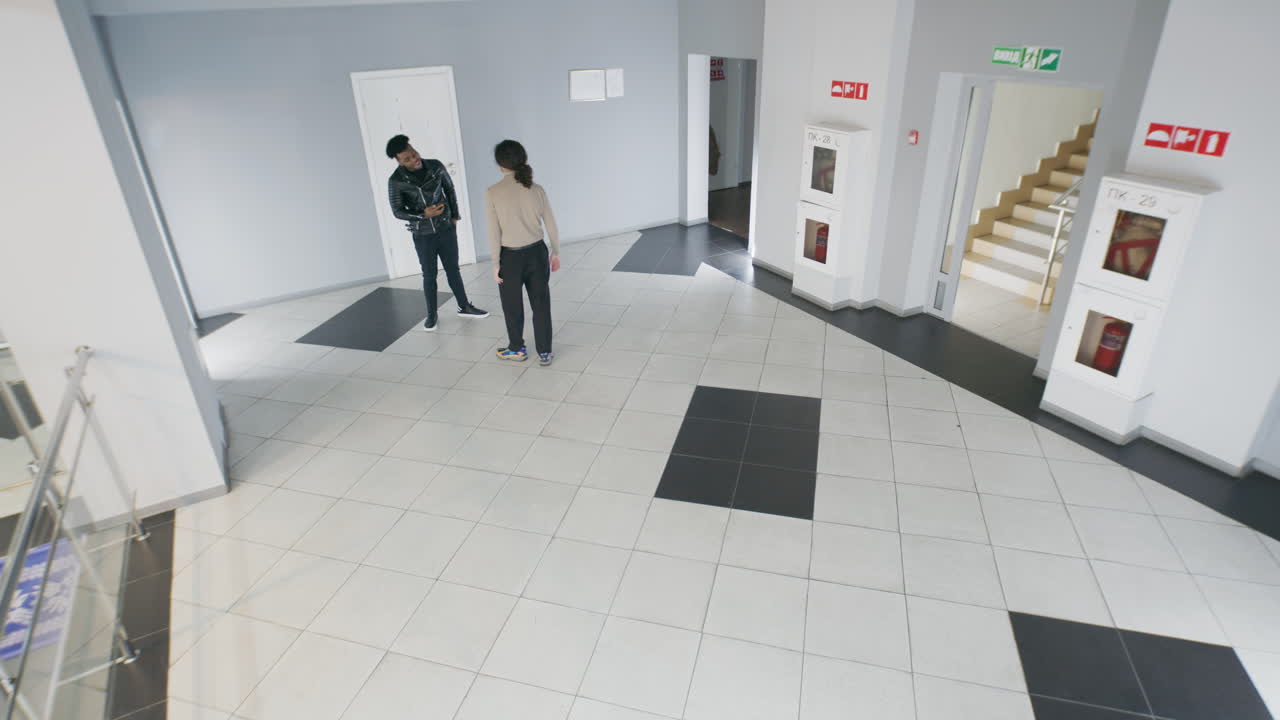 People moving and interacting in an office building hallway
