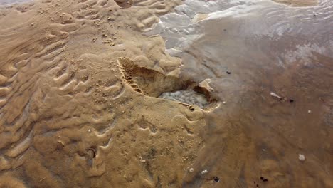 Der-Fußabdruck-Am-Strand-Verschwindet,-Wenn-Er-Sich-Mit-Wasser-Füllt