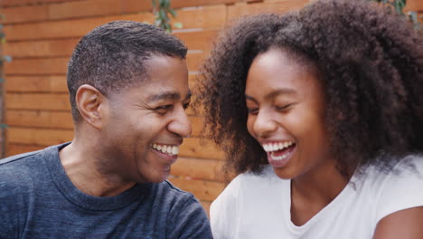 Padre-Negro-De-Mediana-Edad-Y-Su-Hija-Adolescente-Hablando-Y-Sonriendo-Al-Aire-Libre,-De-Cerca