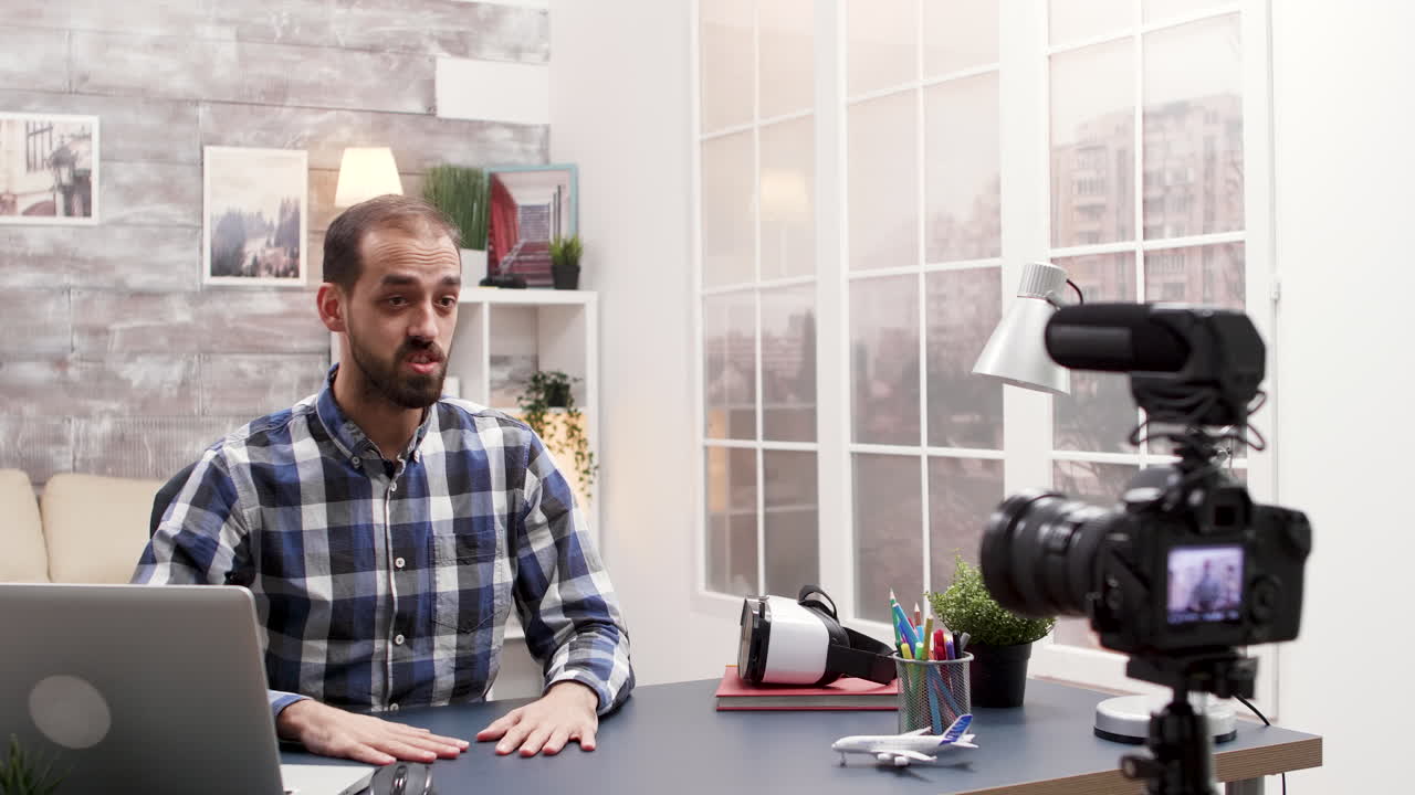 Man recording a video blog in his home office