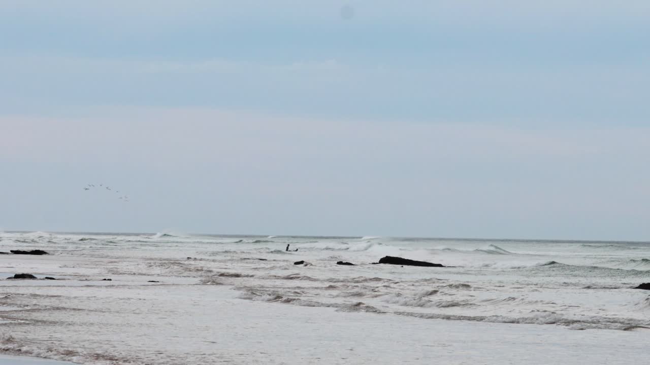 A serene view of waves gently crashing on the shore along the Great Ocean Road, captured under soft daylight