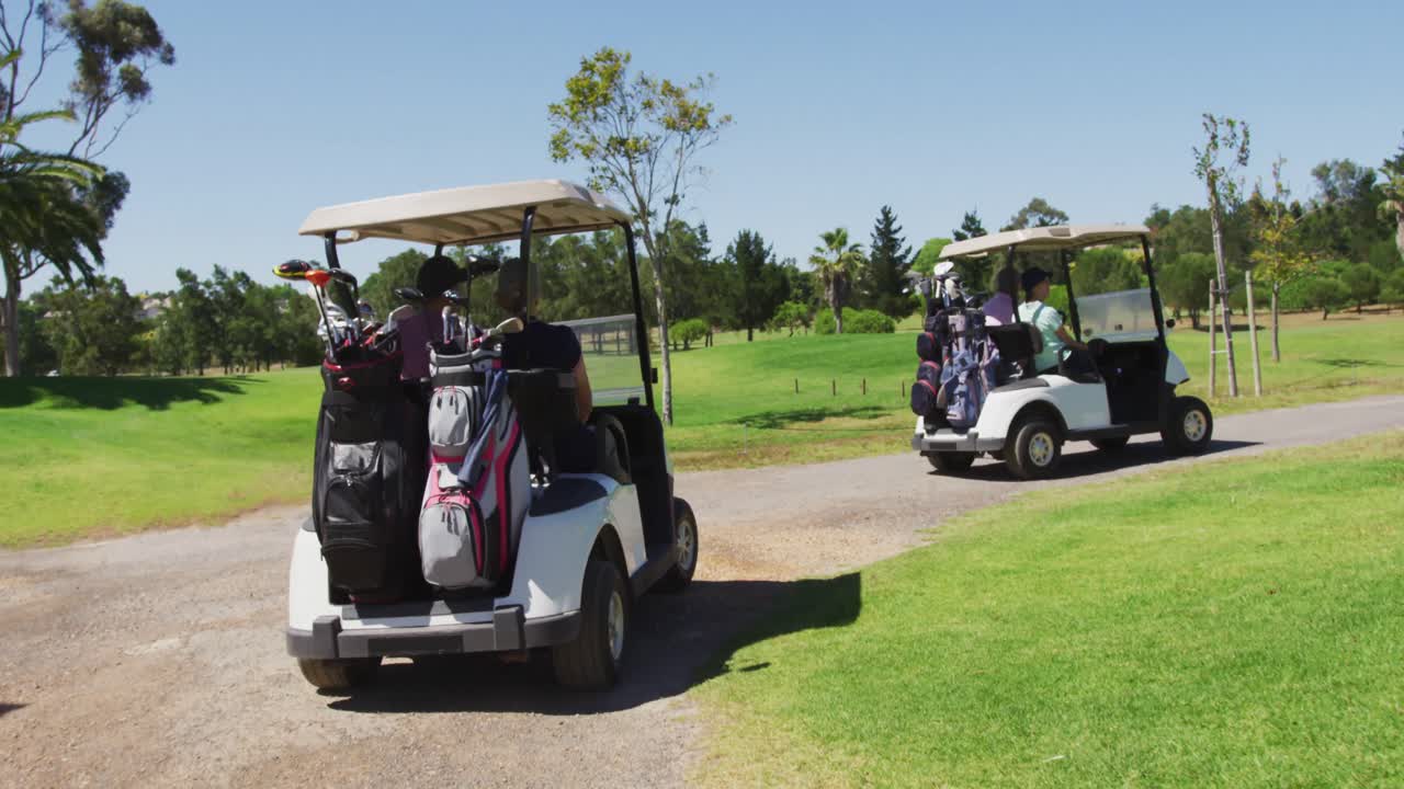 高齢者がゴルフコースの裏側にクラブを持ってゴルフカートを運転している