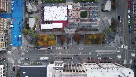 Drohnenaufnahme-über-Dem-Union-Square,-Die-Die-Festliche-Stimmung-Mit-Einem-Hoch-Aufragenden-Weihnachtsbaum-Und-Einer-Belebten-Eislaufbahn-Einfängt