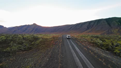 land rover defender blanco conduciendo hacia un paisaje volcánico en el círculo dorado de islandia durante la puesta de sol
