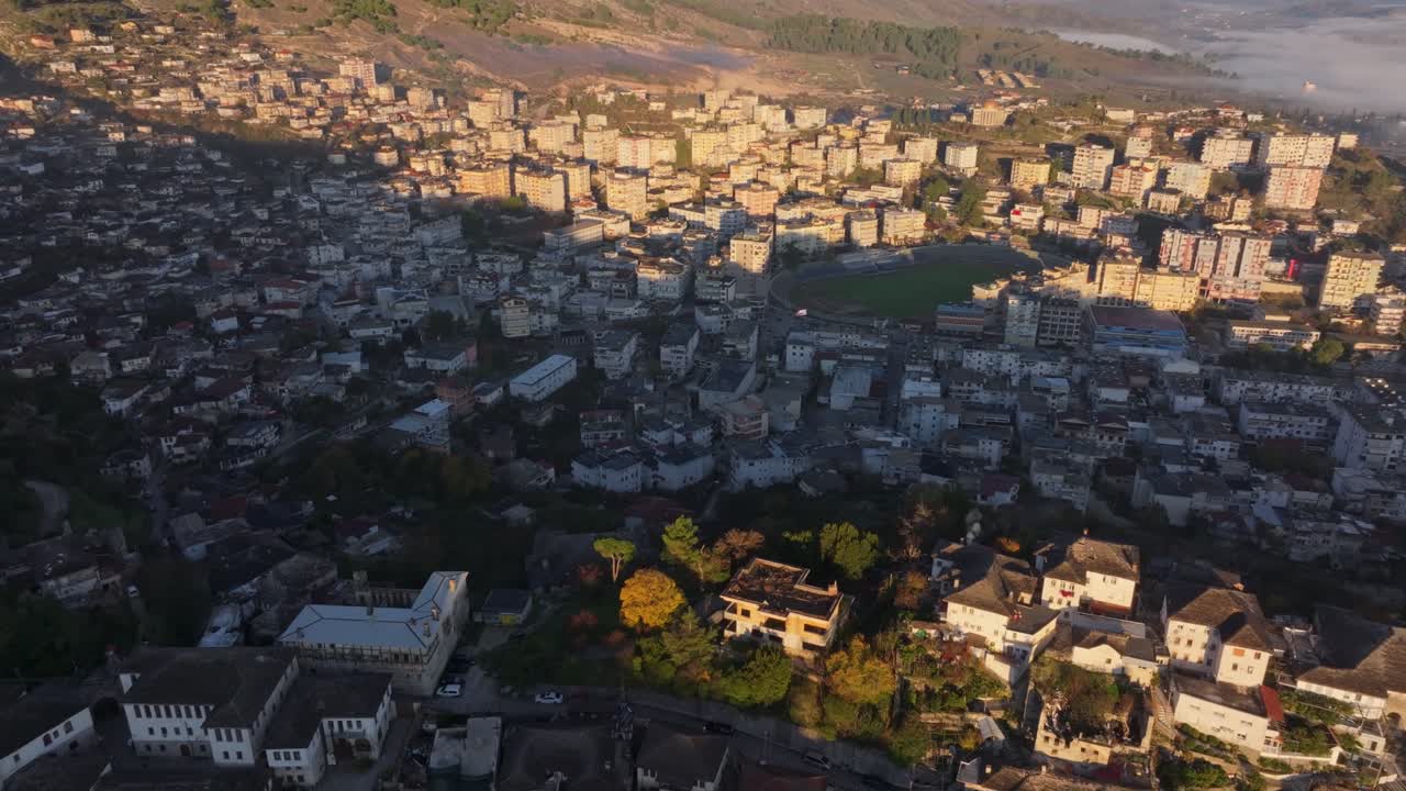 Ripresa da drone della città di Gjirokaster che risplende all'alba con lo Stadiumi Luftetari