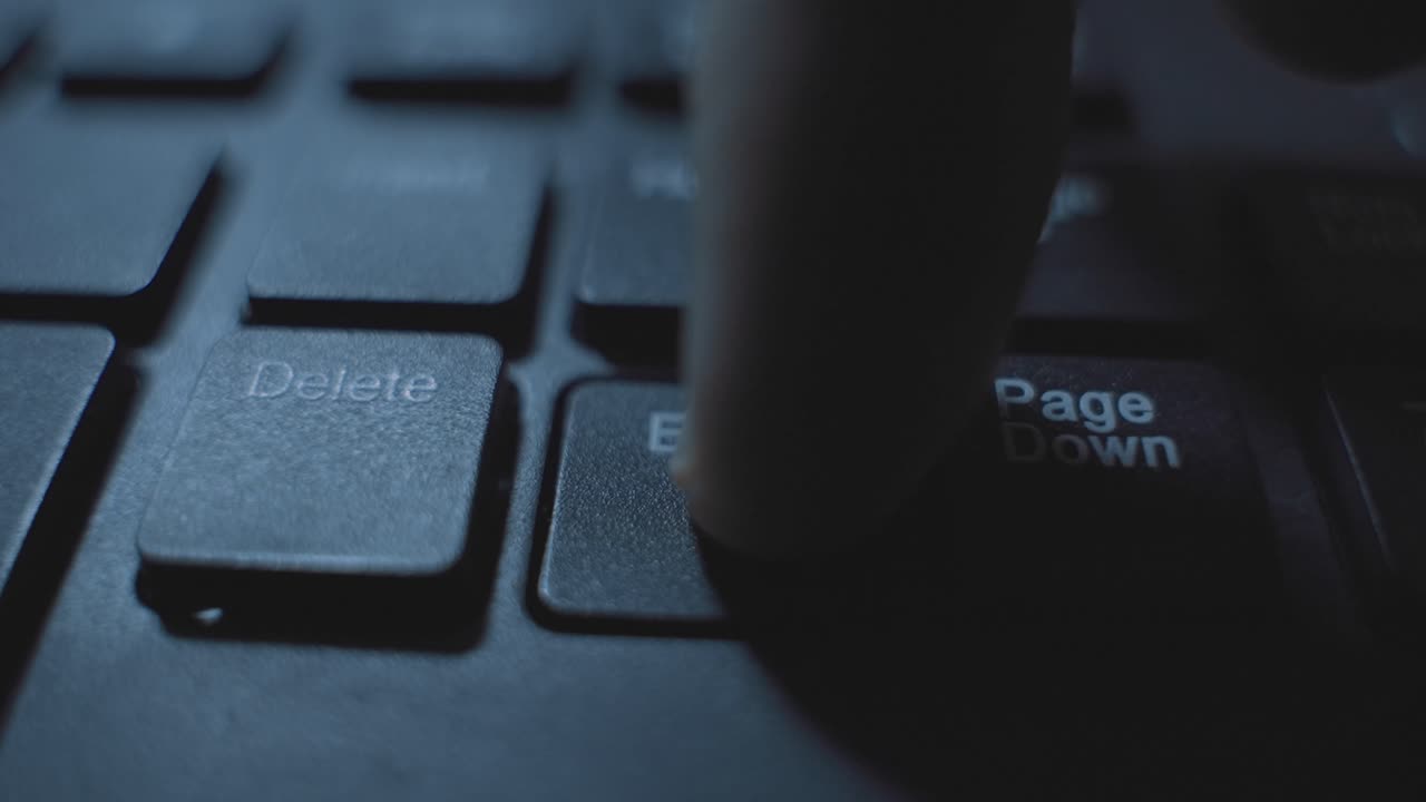 Finger clicking or pressing on End key button on computer keyboard in dark room at night. Coding or hacker pressing to finish task or terminate process. End concept dark web. Delete or remove key