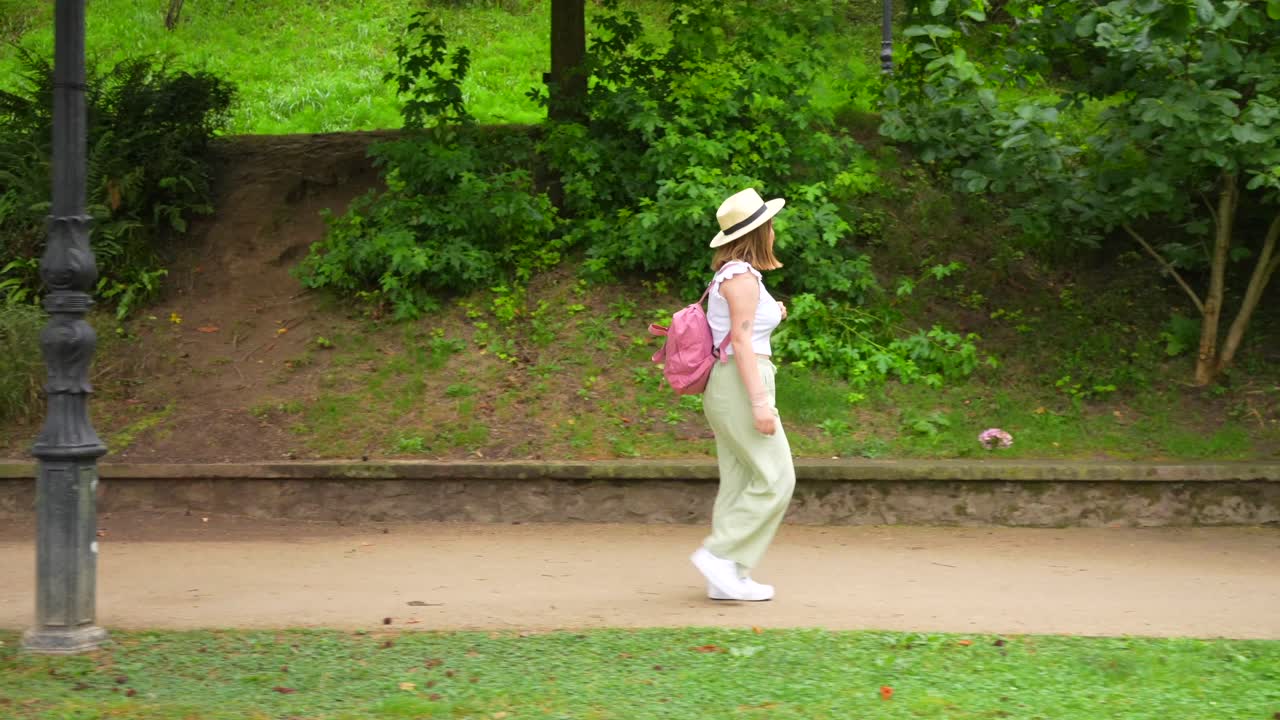 Woman Walking in Park with Backpack