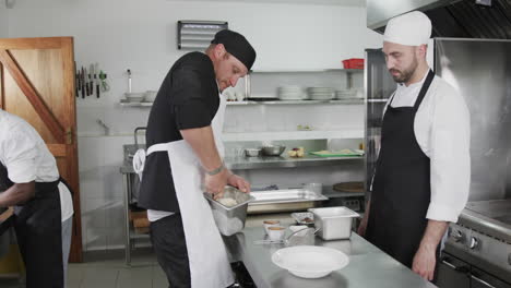 three diverse male chefs preparing meals in kitchen, slow motion