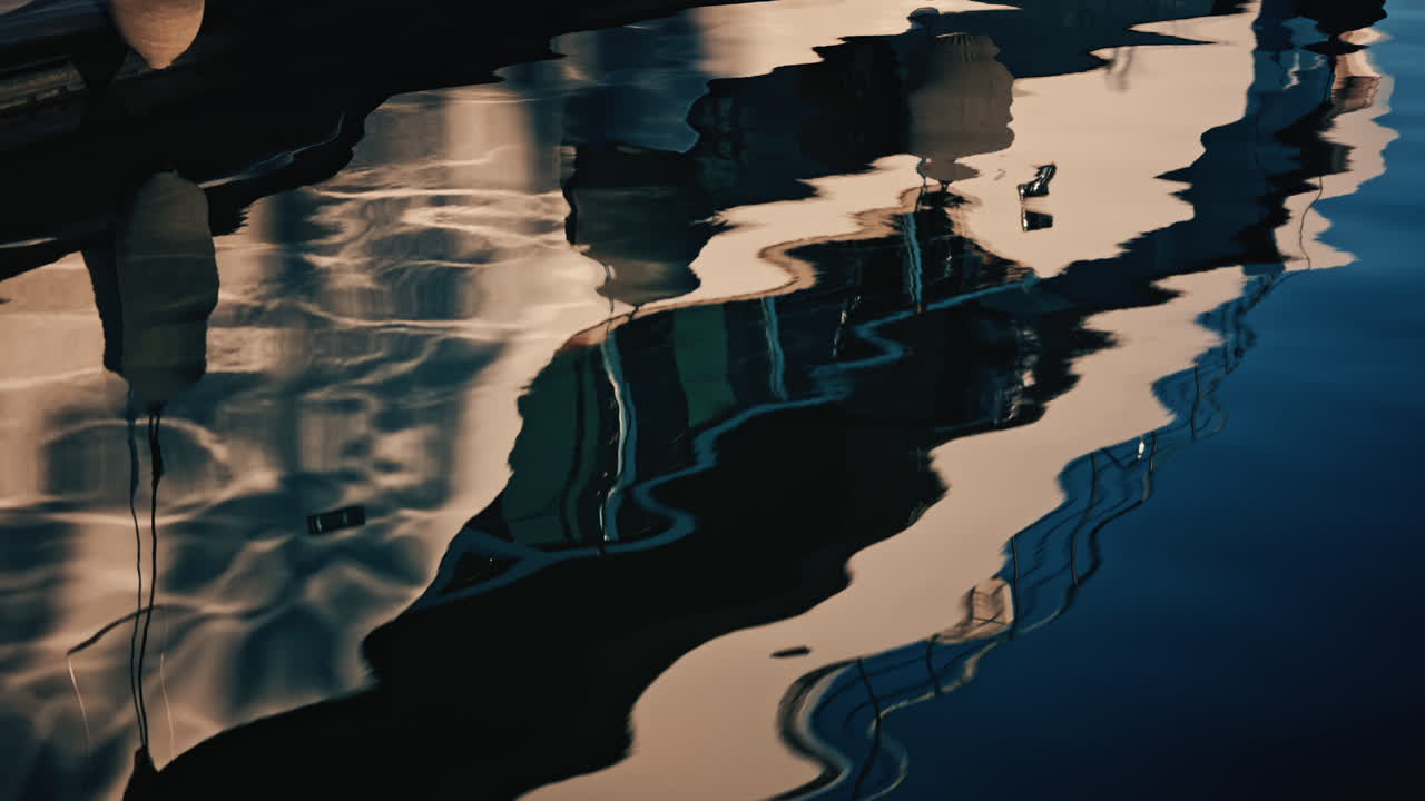Close up view of a modern luxury yacht hull with fenders hanging at a marina