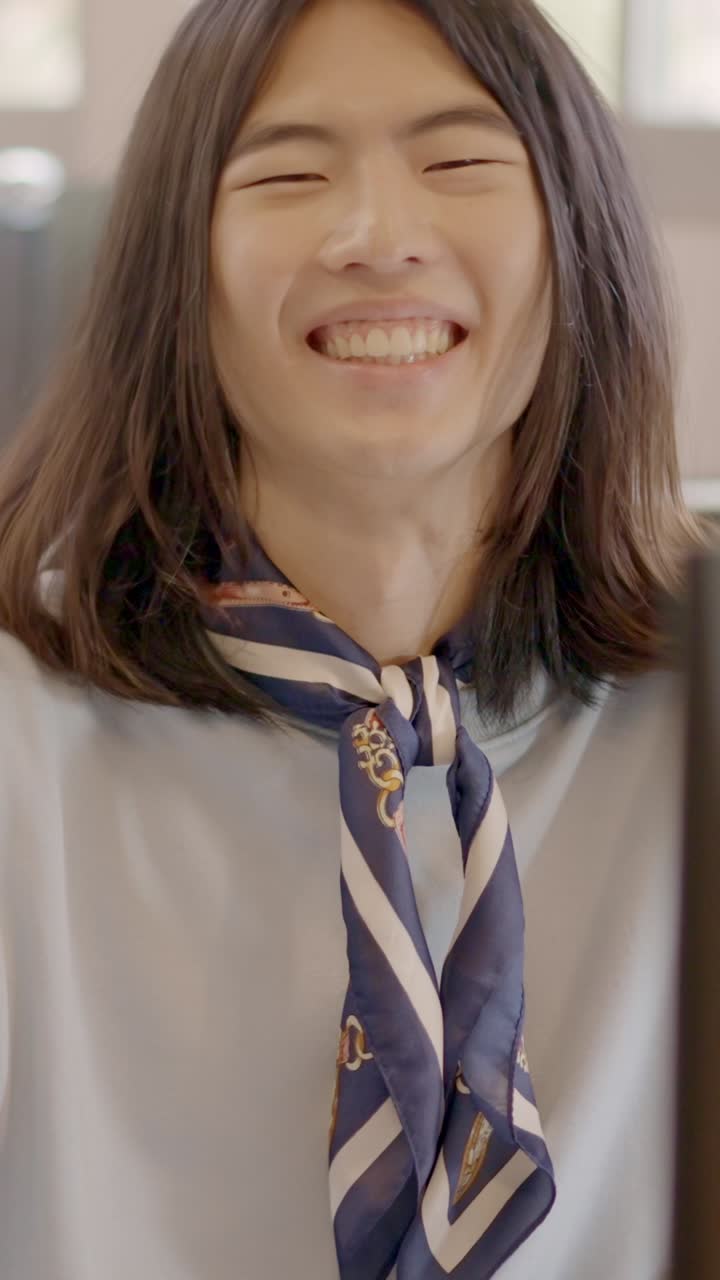 Chinese man working with computer and smiling in a coworking