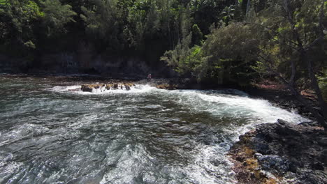 Vuelo-Aéreo-Hacia-Adelante-Sobre-Un-Lago-Natural-Con-Rocas-Sobresalientes-Y-Olas-Rompientes-Durante-El-Día-Soleado-De-Verano