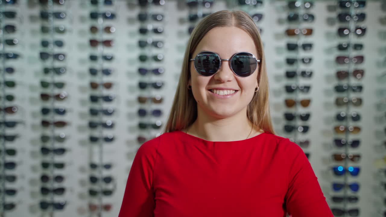 Young woman with eyeglasses. Woman in sunglasses standing in optic store