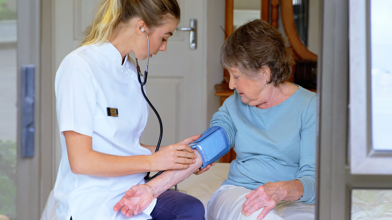 Medico che misura la pressione sanguigna a una donna anziana a letto 4k
