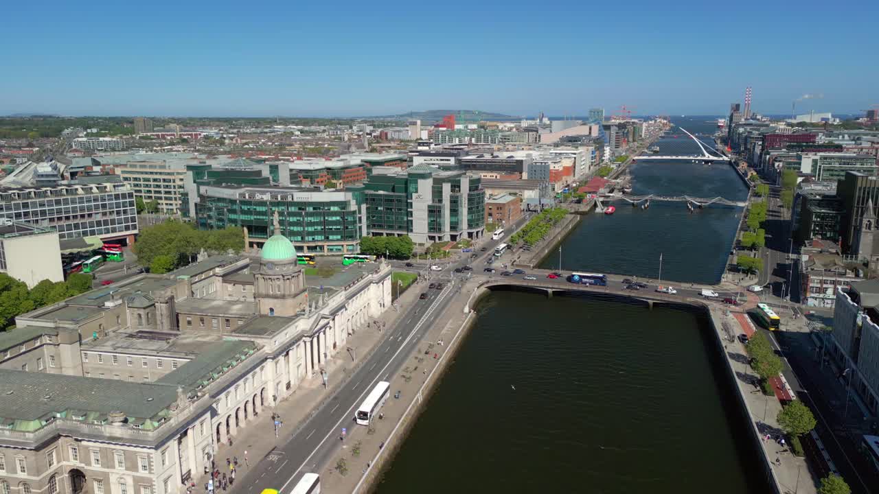 Wide reversing aerial video of Custom House, the River Liffey and the surrounding area in Dublin, Ireland, on a bright and sunny day. Filmed in 4K, 60FPS and with Rec709 color.