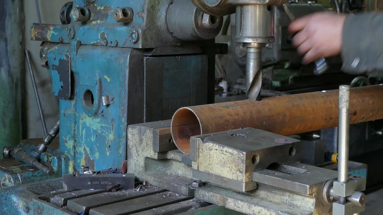 Trapano che fa fori nel tubo