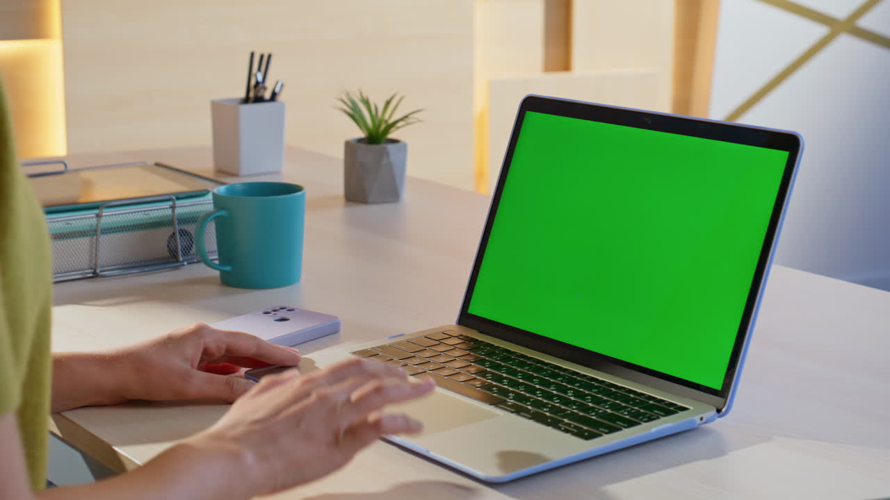 Workspace with laptop and green screen