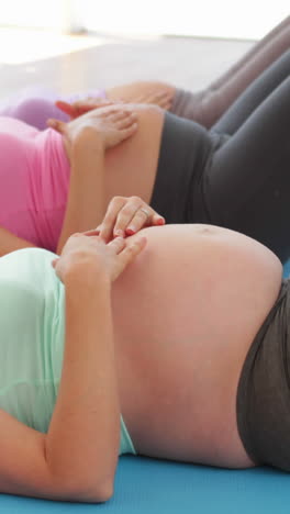 pregnant women doing yoga in fitness studio