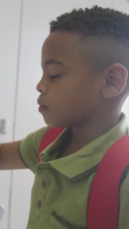 video of african american boy closing locker and smiling at school