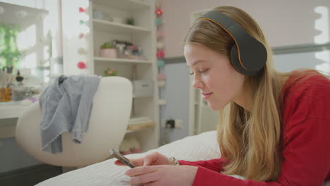 teenage girl wearing wireless headphones streaming music or film from mobile phone  -s hot in slow motion