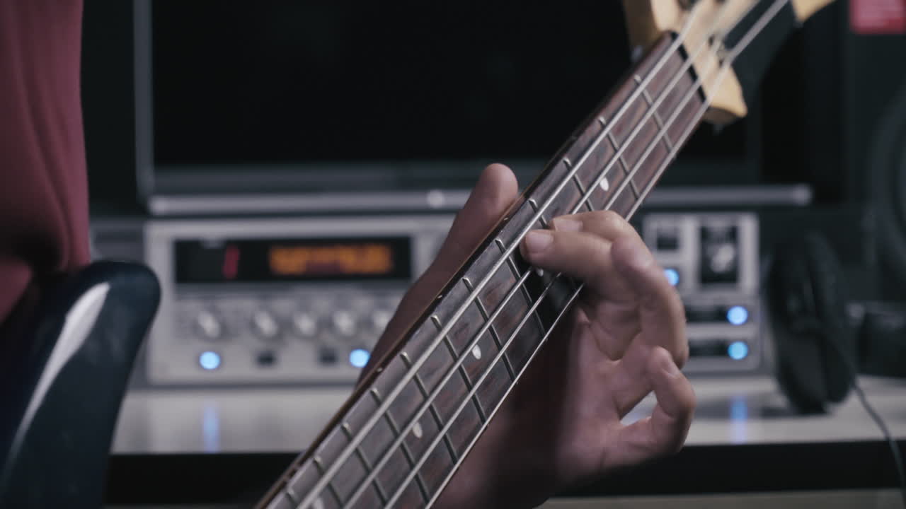 음악가가 베이스 기타를 연주합니다.