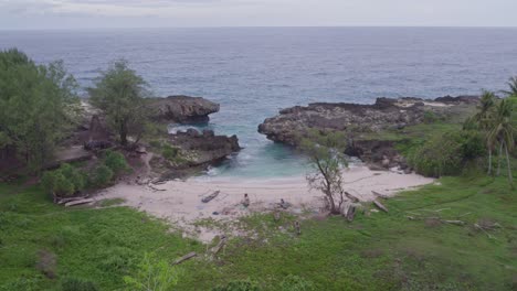 Drone-flies-towards-Mandorak-beach-with-wooden-boats-on-the-shore,-aerial