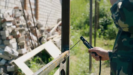 Arbeiter-Schweißt-Zaun-In-Der-Nähe-Von-Landhaus,-Nahaufnahme,-Seitenansicht