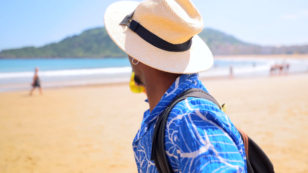 Man enjoying a beach vacation with a pineapple drink
