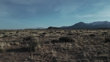 Aerial-dolly-in-of-desert-in-Utah,-USA-with-mountain-background