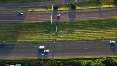 a busy highway drone clip showing free flowing traffic travelling in both directions with green grass separating the two sides