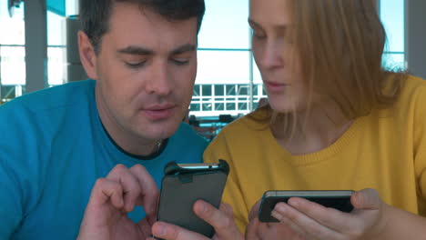 una pareja joven con teléfonos inteligentes.