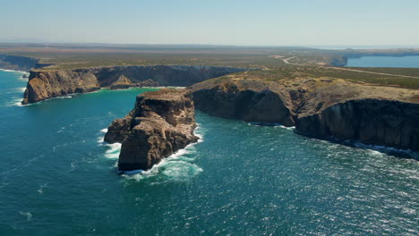 Panoramic-aerial-view-of-the-Pedra-das-Gaivotas-with-cliffs-around-it-in-Cape-Saint-Vicente-Algarve,-Portugal