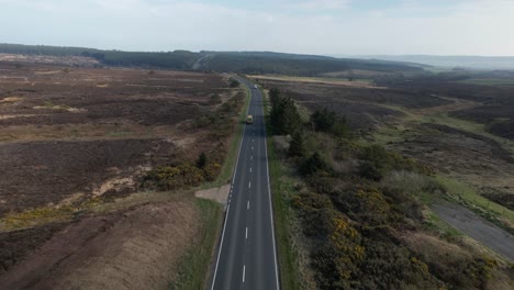 aerial of alone bus driving in the street of goathland - north york moors national park uk