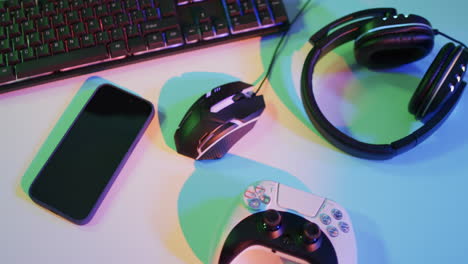 Video of gaming computer and gaming equipment on desk with copy space on neon background