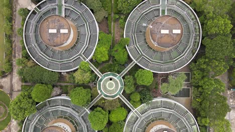 drone aerial view of sewage water treatment plant with storage tanks, trees