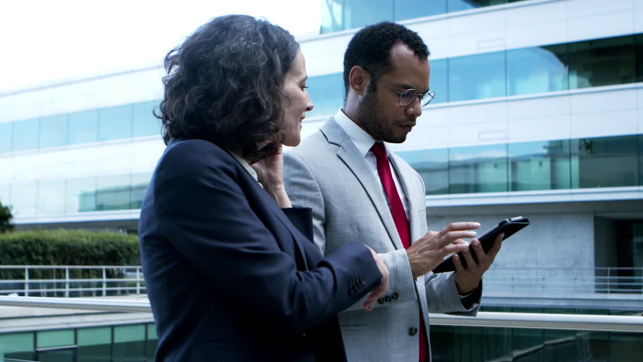 Smiling business people with digital devices