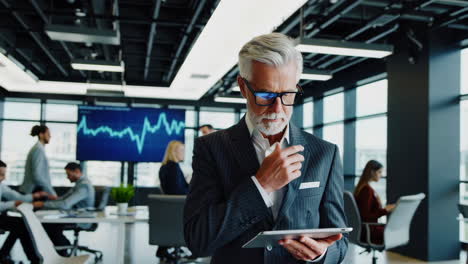 senior businessman using tablet in a modern office environment