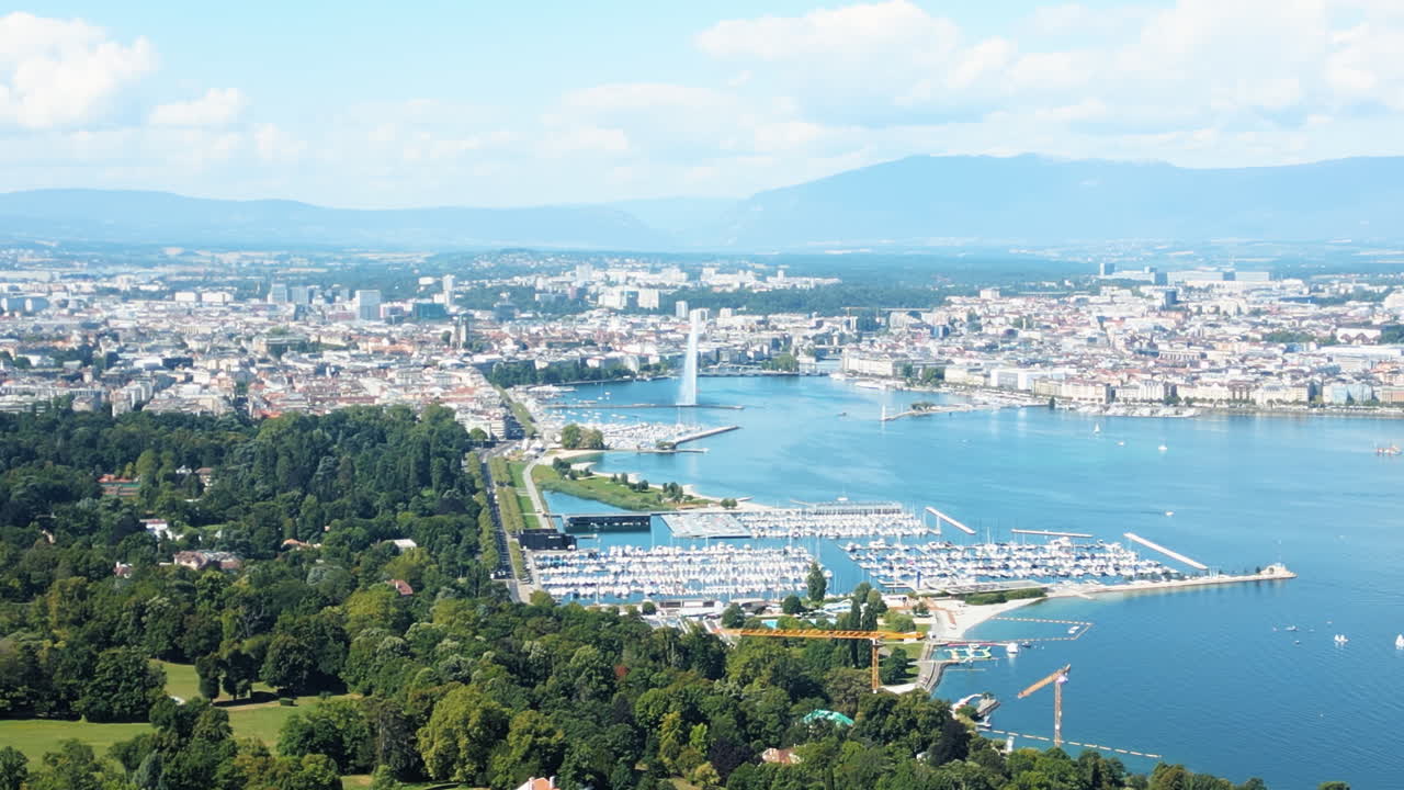 Push in drone shot of water fountain of Geneva during the day (Rade of Geneva) from Cologny, Switzerland