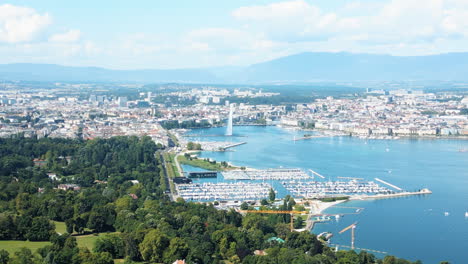push in drone shot of water fountain of geneva during the day (rade of geneva) from cologny, switzerland
