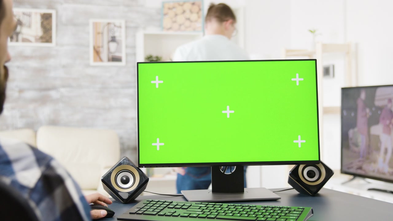 Man Working on Computer with Green Screen Monitor in Home Office