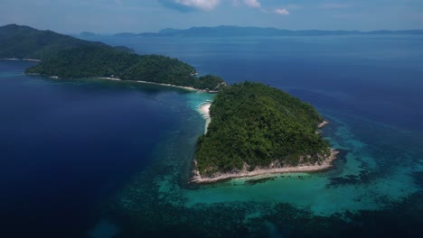 drone aerial shot of exotic island surrounded by turquoise waters in palawan, philippines