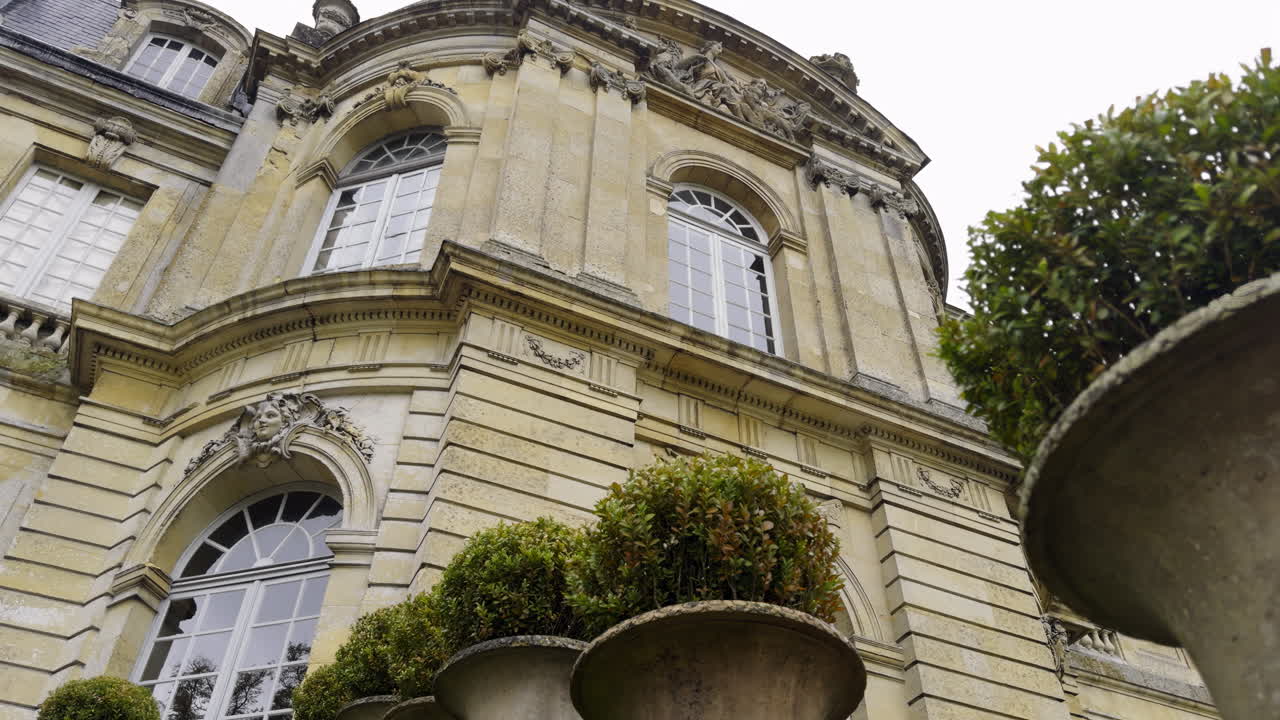 Elegant Facade of a Historic Chateau with Ornamental Gardens