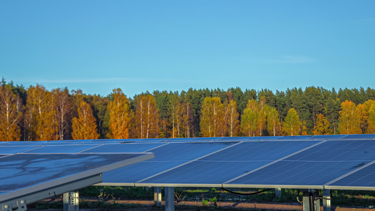 Solar panels in a sunny autumn landscape with colorful trees