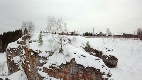 snowy winter landscape with rocky cliff and village