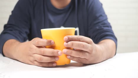 person holding a yellow cup