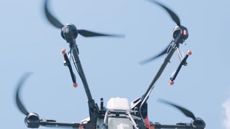 drone sprayer flies over the agricultural field. agriculture drone for spraying fertilizer on the blue sky. smart farming and precision agriculture