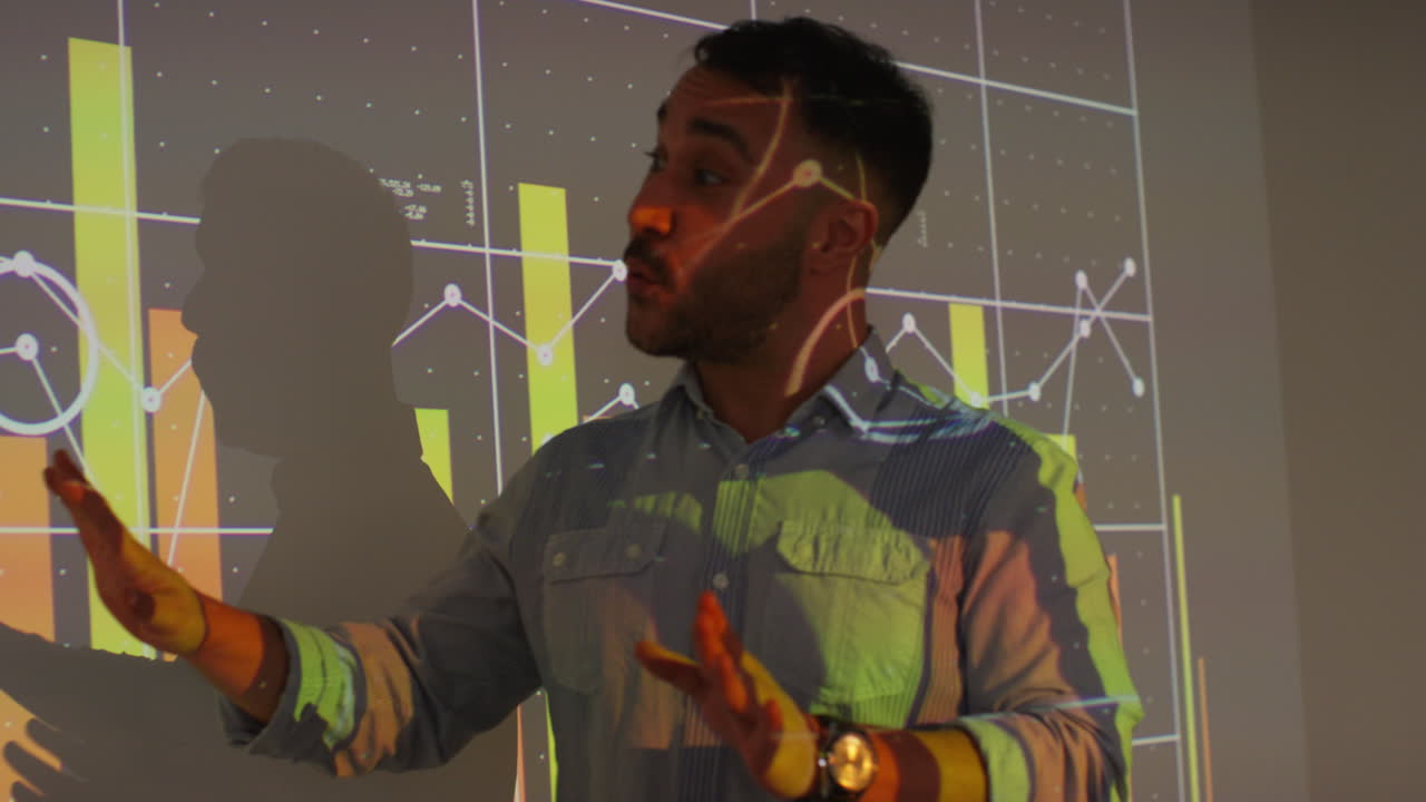 Male Teacher Giving Maths Or Science Lesson In School Standing At The Front Of Class With Projection Of Graph 1