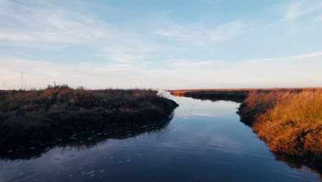 slow and low drone flight through burnt orange watery unreal landscape