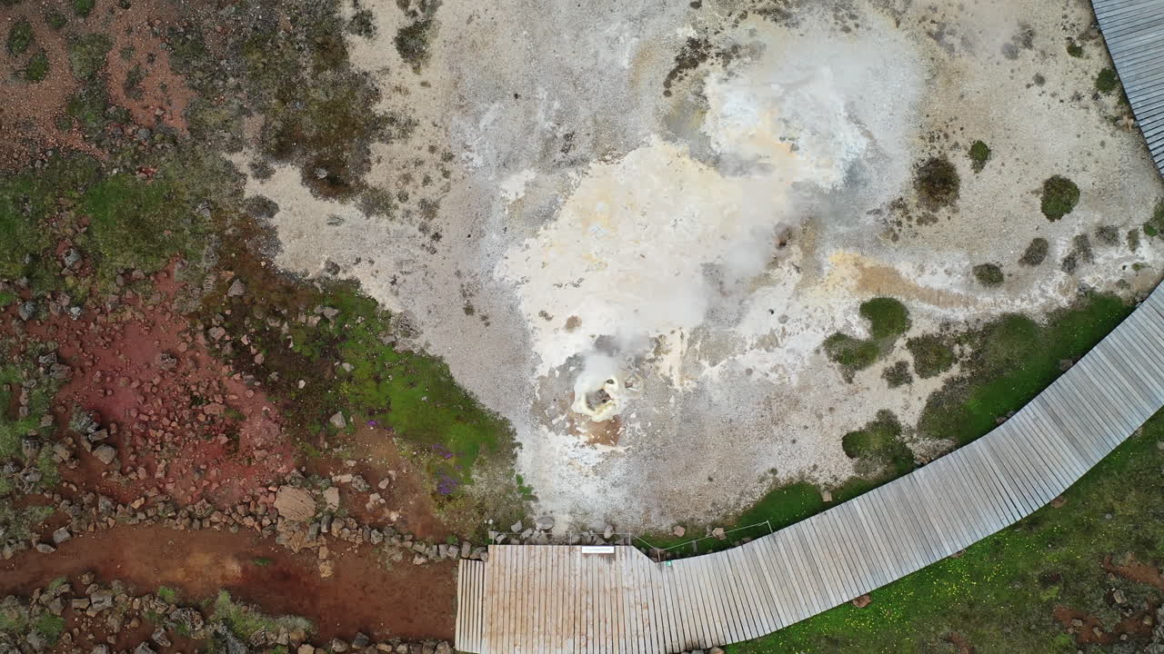 tierra humeante con agua geotérmica caliente en hveravellir en las tierras altas de islandia - dron ascendente, de arriba hacia abajo