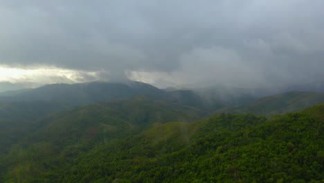 Ein-Drohnenschuss-Bewegt-Sich-An-Einem-Regnerischen-Tag-In-Richtung-Eines-Tropischen-Bergtals-Und-Dringt-Langsam-In-Den-Wolkigen-Nebel-Ein,-Der-Die-Gipfel-Umgibt